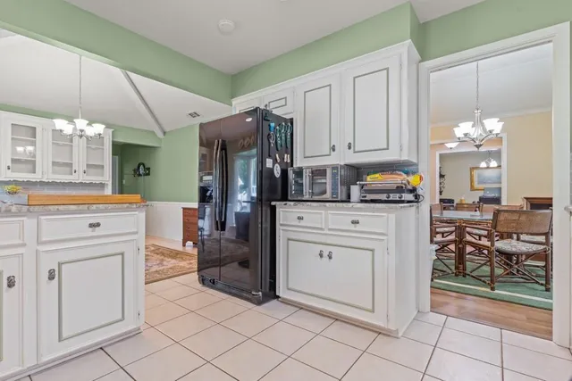 a kitchen with white cabinets and appliances