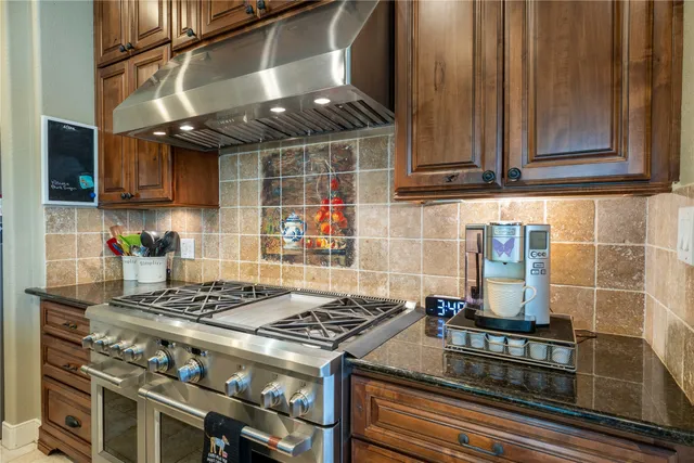 a kitchen with granite countertop a stove and a refrigerator