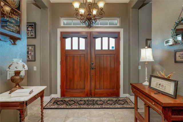 a view of hall way with furniture and chandelier