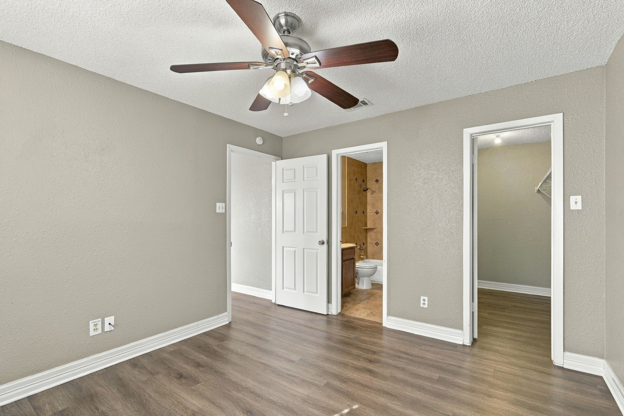 8804 Schick Road, Unit C Austin, TX 78729 - Photo 10 of 17 Rich wood-inspired flooring pairs beautifully with neutral walls in this versatile bedroom suite.