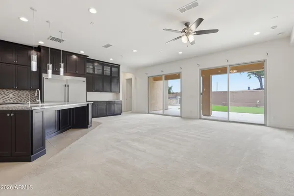 a open kitchen with stainless steel appliances kitchen island granite countertop a refrigerator oven a sink with dishwasher and white cabinets