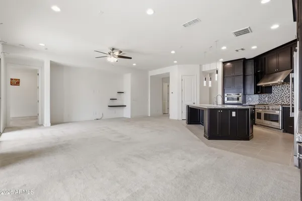 a large room with stainless steel appliances kitchen island granite countertop a stove and a sink