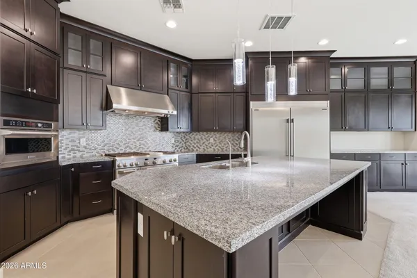 a kitchen with kitchen island granite countertop a wooden floor and cabinets