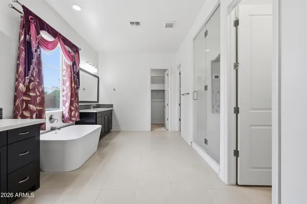 a spacious bathroom with a double vanity sink mirror and bathtub