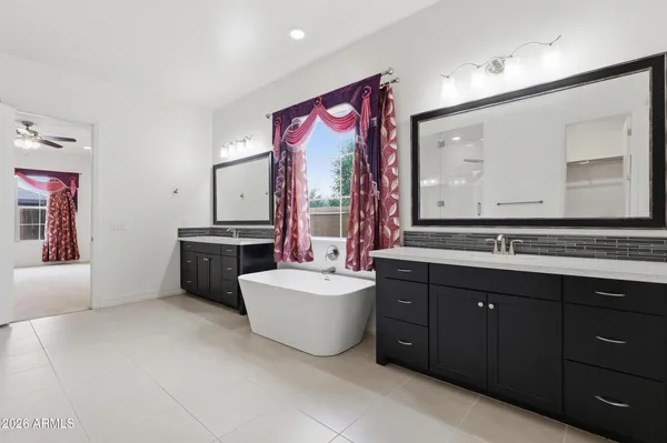 a spacious bathroom with a bathtub sink mirror and window