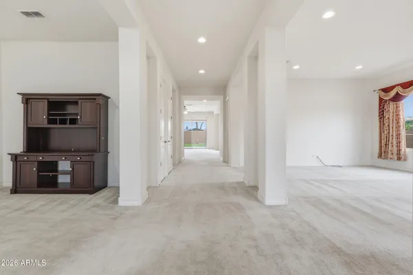 a view of a hallway with wooden floor and windows