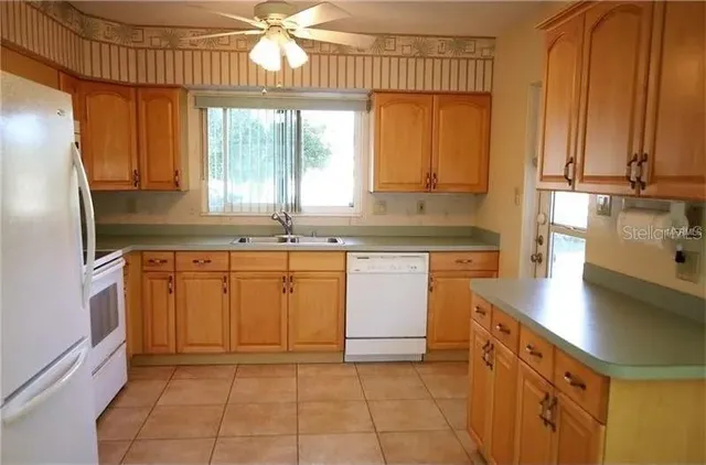 a kitchen with cabinets a window and stainless steel appliances