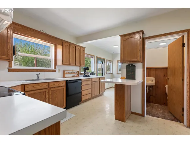 a kitchen with kitchen island granite countertop a sink cabinets and stainless steel appliances