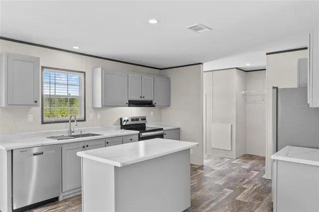 a kitchen with stainless steel appliances a sink stove and refrigerator