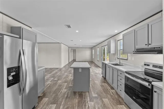 a kitchen with stainless steel appliances a refrigerator sink and stove