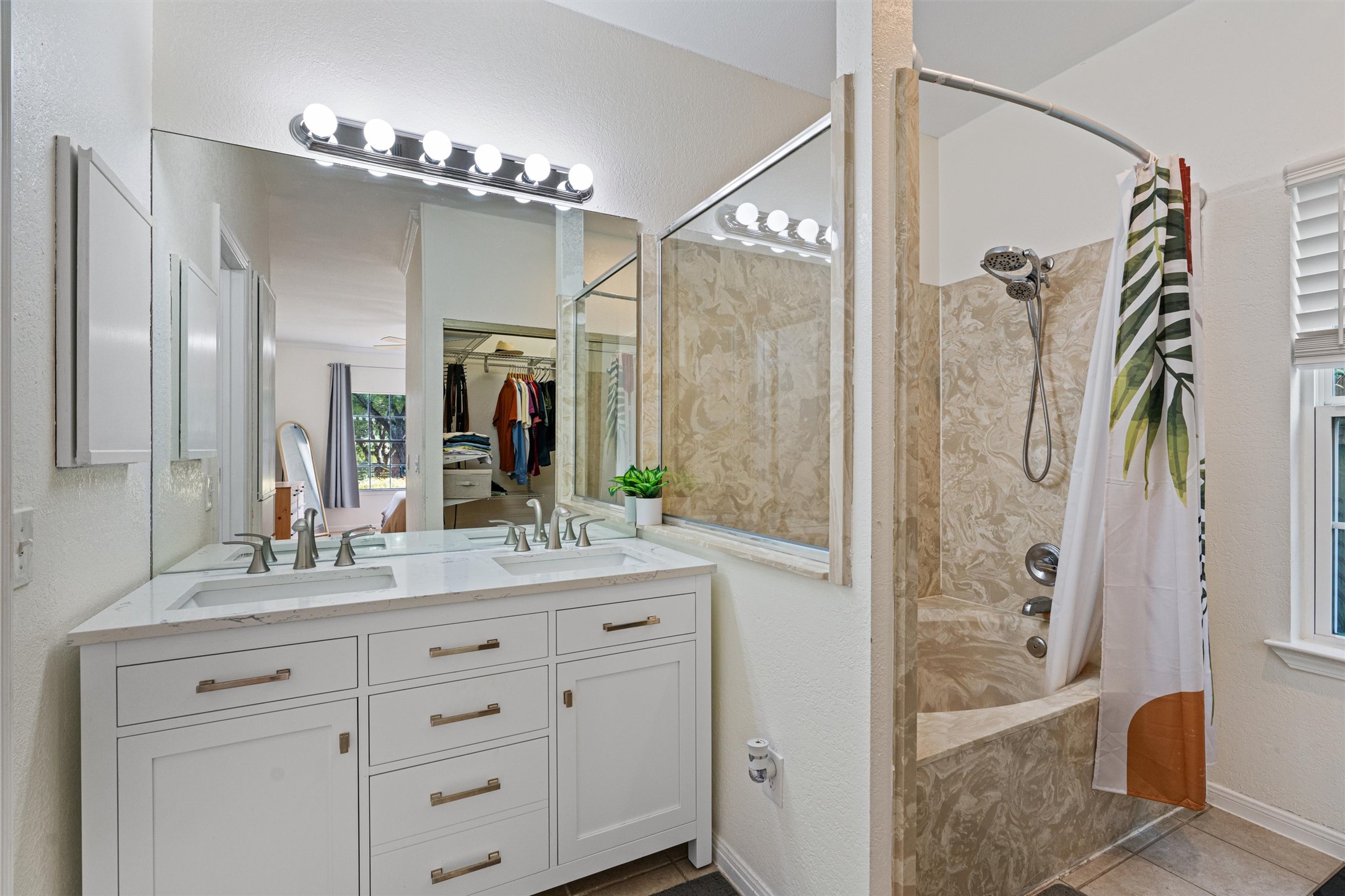 2010 Cervin Boulevard Austin, TX 78728 - Photo 17 of 32 a bathroom with a granite countertop sink a mirror a bathtub and shower
