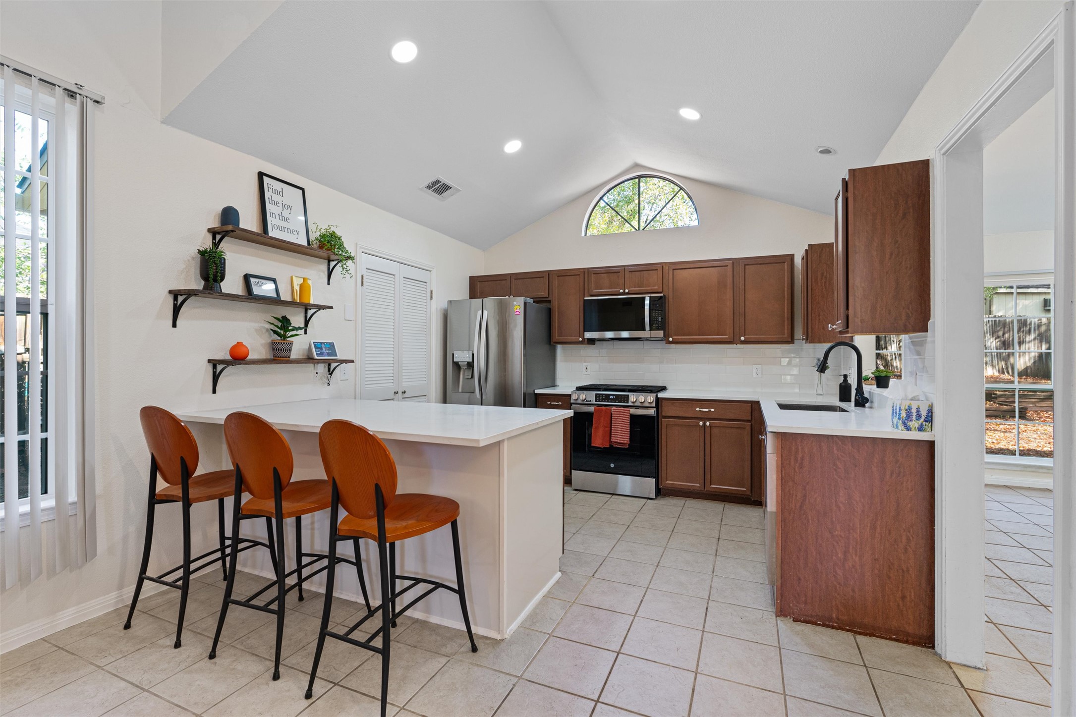 2010 Cervin Boulevard Austin, TX 78728 - Photo 6 of 32 a kitchen with stainless steel appliances kitchen island granite countertop a table chairs and a refrigerator