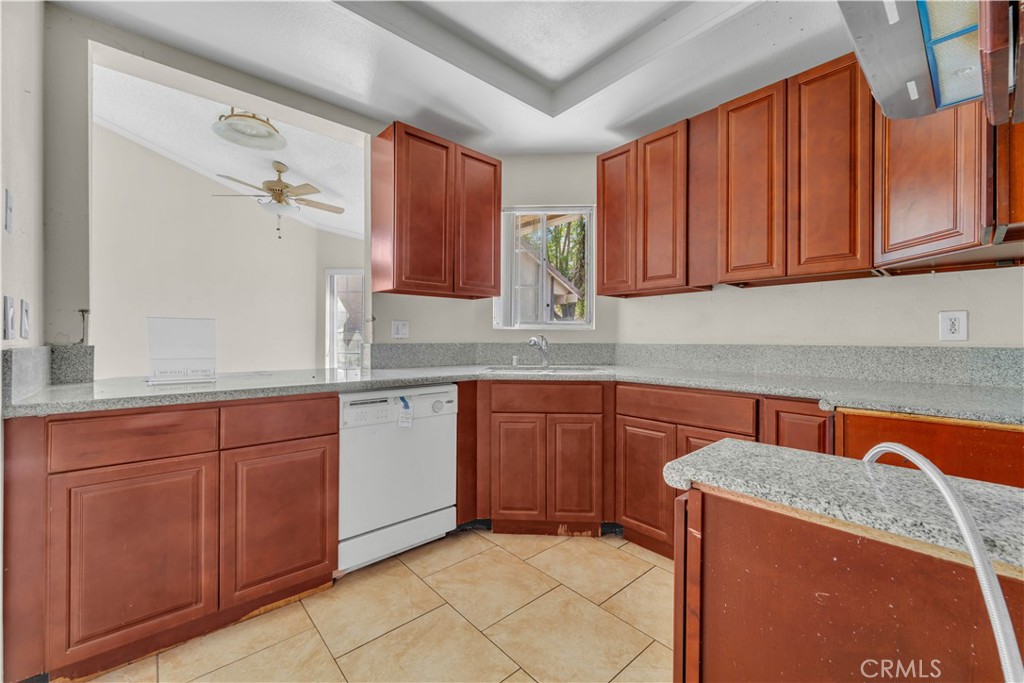 36806 Meadowview Court Palmdale, CA 93552 - Photo 3 of 17 a kitchen with stainless steel appliances granite countertop wooden cabinets a sink and dishwasher