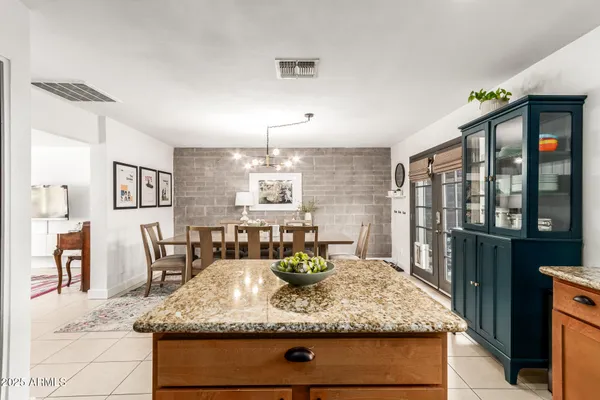 a kitchen with kitchen island granite countertop a table and chairs