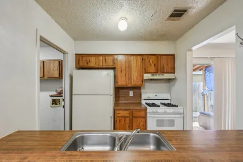 a kitchen with a refrigerator sink and cabinets