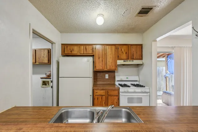 a kitchen with a refrigerator sink and cabinets