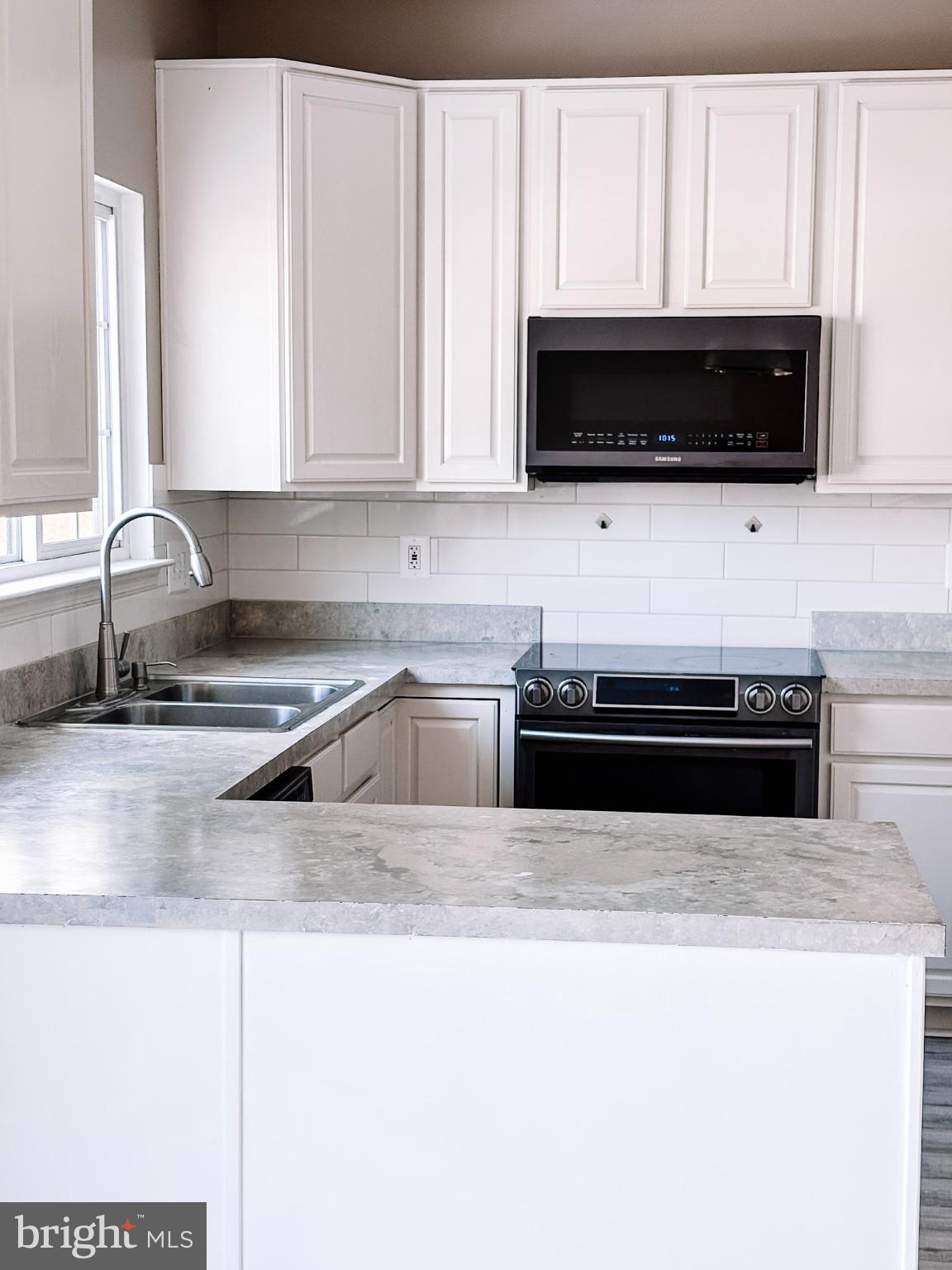 6151 Newton Lane Bealeton, VA 22712 - Photo 16 of 47 a kitchen with stainless steel appliances a stove a microwave sink and cabinets