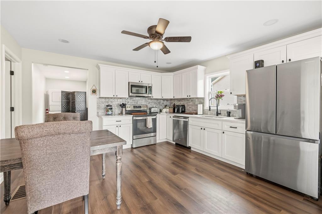 156 Pine Avenue Commerce, GA 30529 - Photo 22 of 35 a kitchen with stainless steel appliances white cabinets and a refrigerator