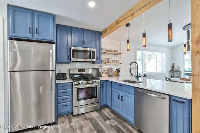 a kitchen with stainless steel appliances granite countertop a refrigerator stove a sink dishwasher and microwave with wooden cabinets