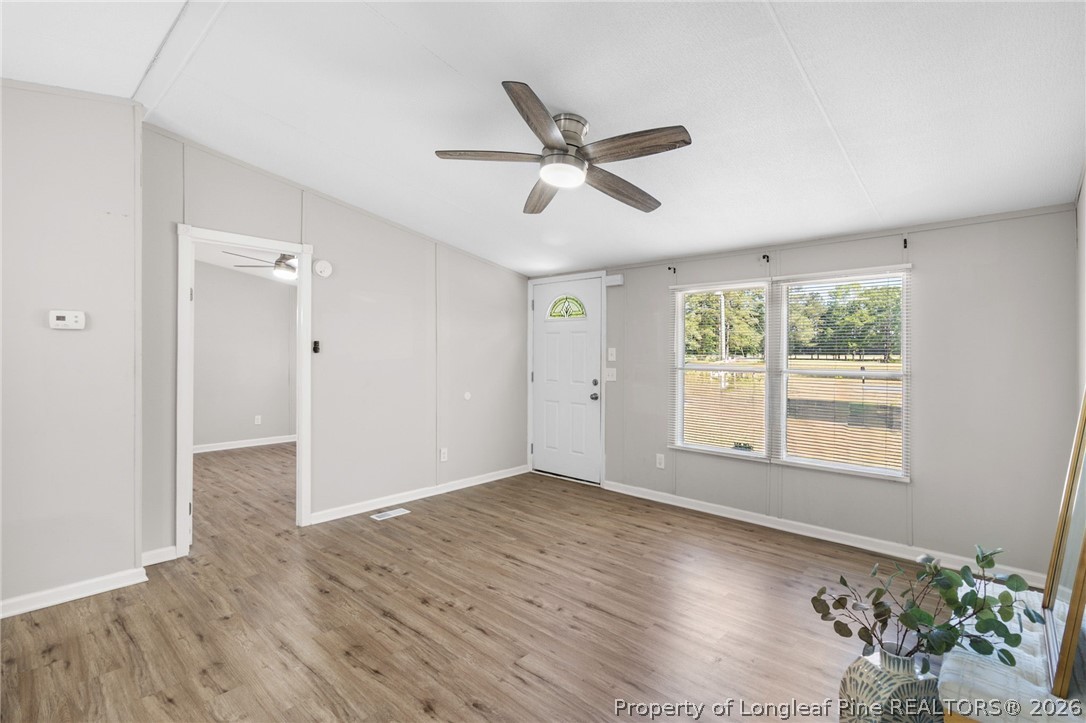 6568 Sandy Creek Road Stedman, NC 28391 - Photo 11 of 34 a view of empty room with wooden floor and fan