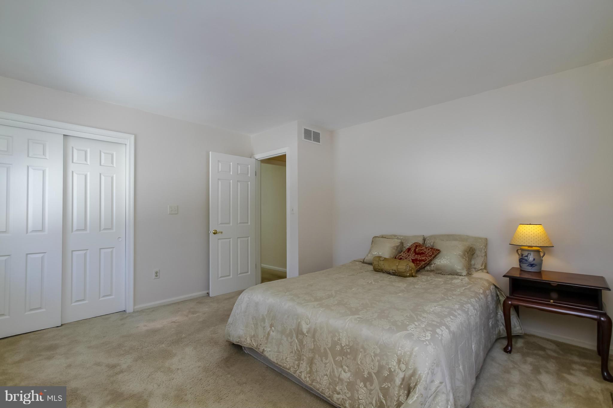14015 Foxland Road Phoenix, MD 21131 - Photo 18 of 24 a bedroom with a bed and a lamp