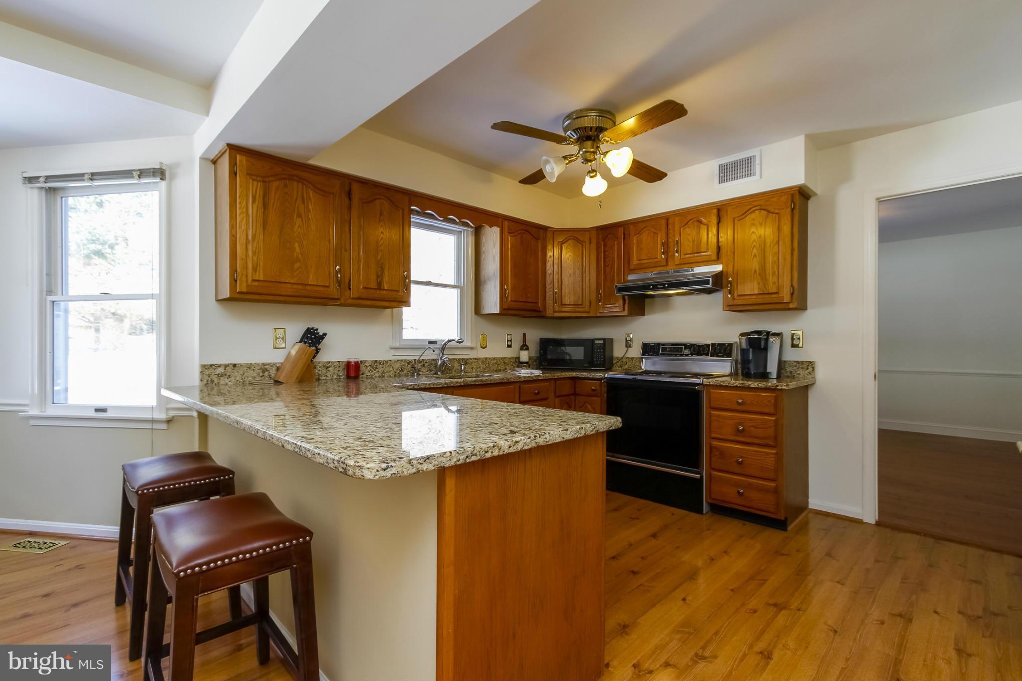 14015 Foxland Road Phoenix, MD 21131 - Photo 7 of 24 a kitchen with granite countertop a sink appliances cabinets and furniture