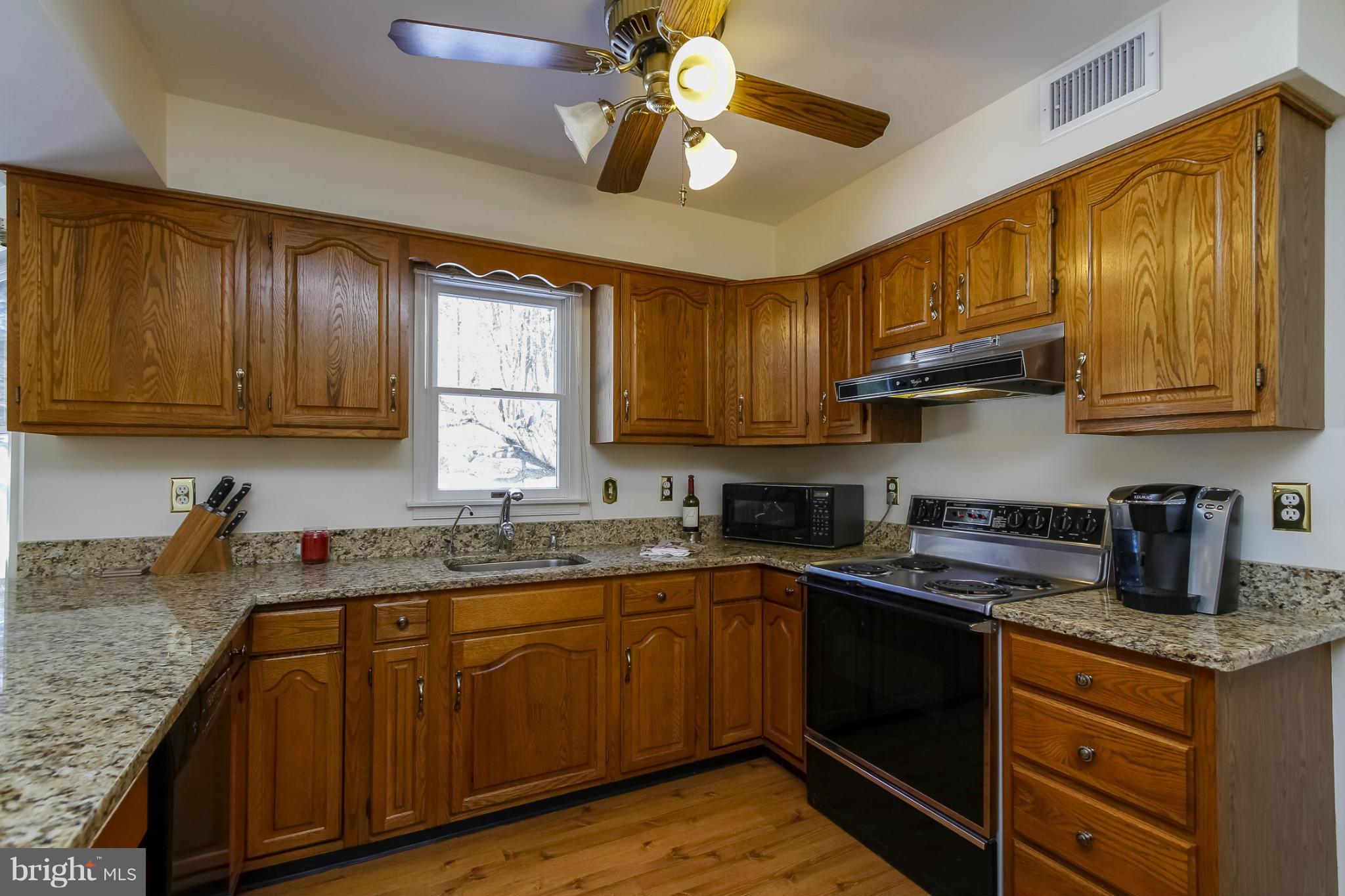 14015 Foxland Road Phoenix, MD 21131 - Photo 8 of 24 a kitchen with stainless steel appliances granite countertop wooden cabinets a stove a sink and dishwasher