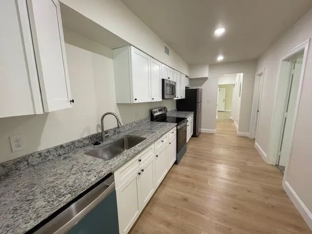 a large kitchen with kitchen island granite countertop a sink and dishwasher stove top oven