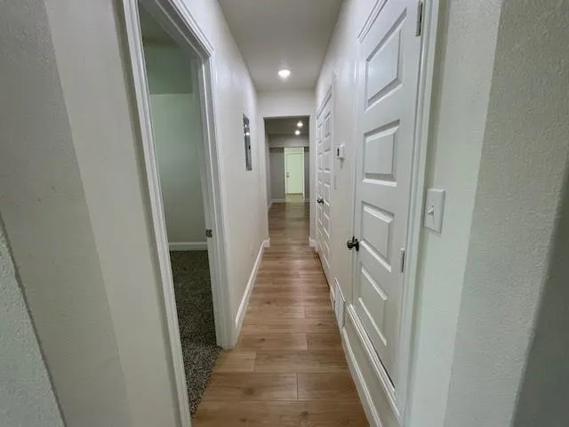 a view of a hallway with wooden floor and staircase