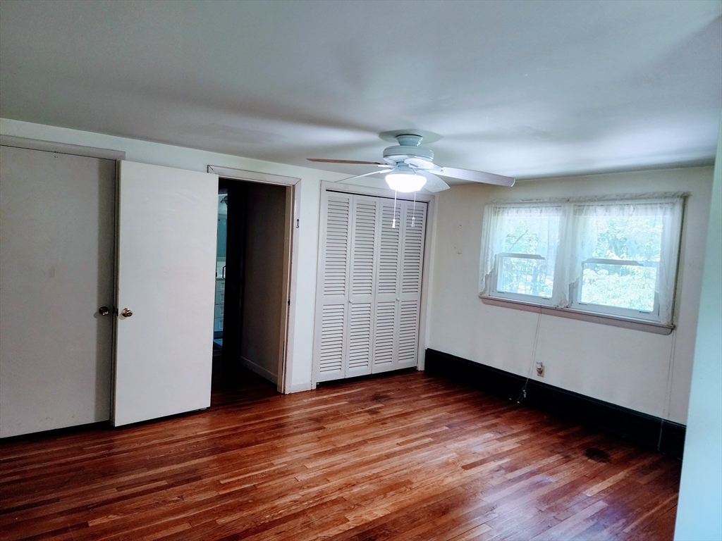 300 Mason Rd Extension Dudley, MA 01571 - Photo 18 of 42 an empty room with wooden floor chandelier and windows
