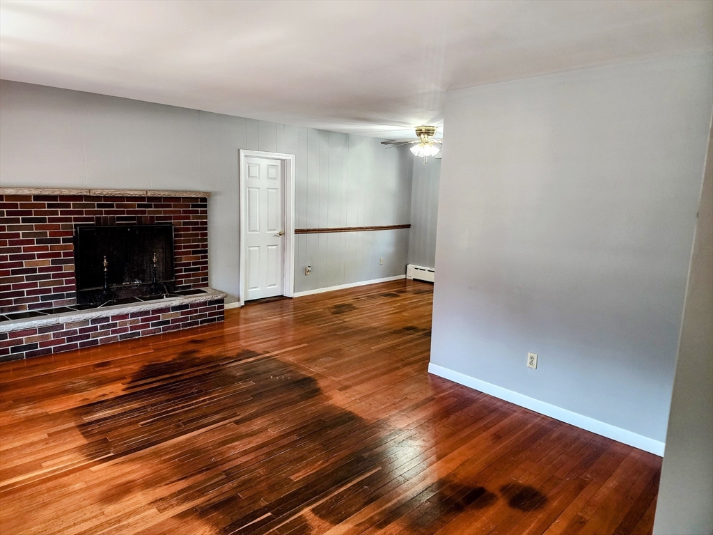 300 Mason Rd Extension Dudley, MA 01571 - Photo 35 of 42 a view of empty room with wooden floor and fireplace