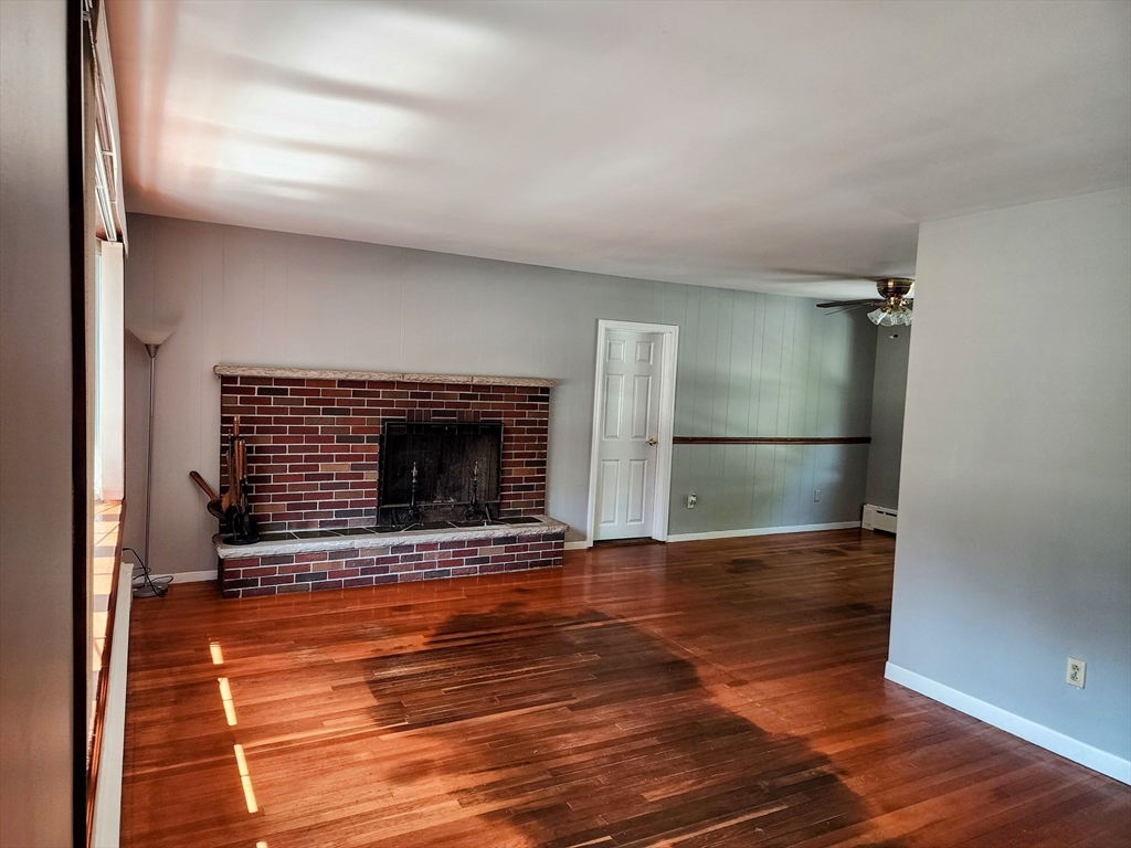 300 Mason Rd Extension Dudley, MA 01571 - Photo 8 of 42 a view of an empty room with wooden floor and a fireplace