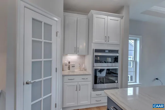 a kitchen with white cabinets and appliances