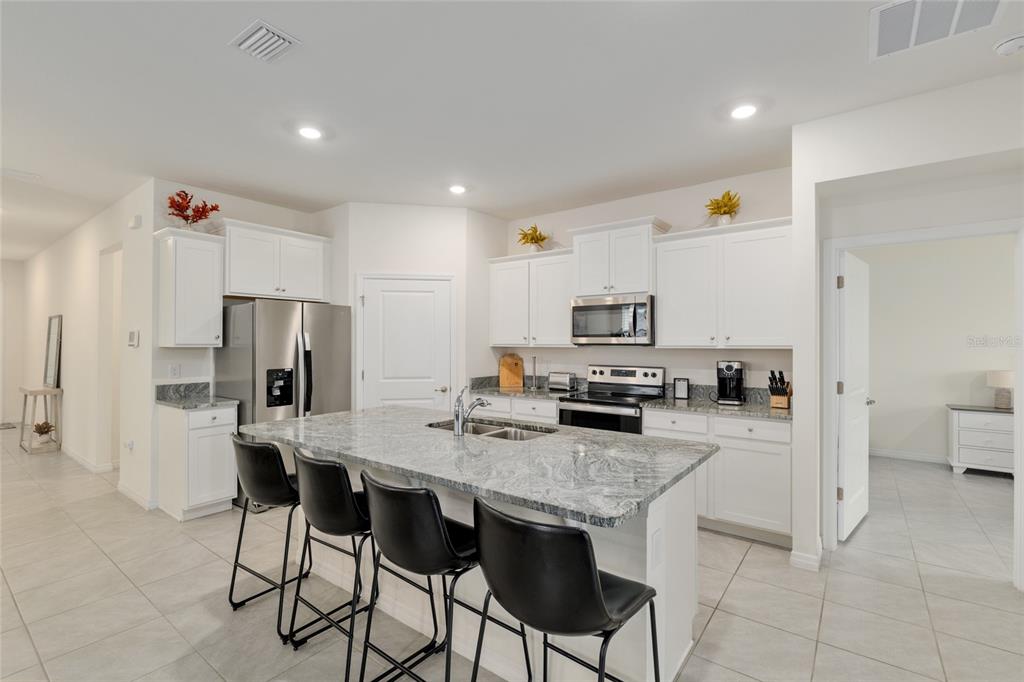 5246 Northwest 43rd Ln Road Ocala, FL 34482 - Photo 18 of 84 a kitchen with stainless steel appliances a stove top oven a refrigerator a sink and a stove