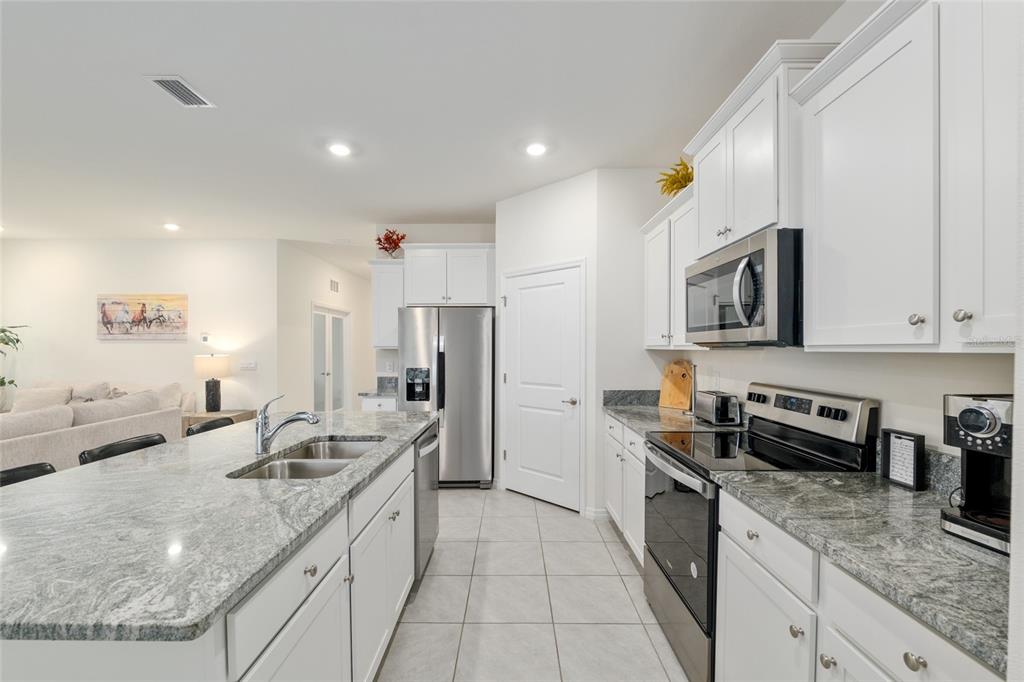 5246 Northwest 43rd Ln Road Ocala, FL 34482 - Photo 22 of 84 a kitchen with stainless steel appliances granite countertop a sink stove and refrigerator