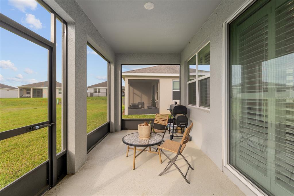 5246 Northwest 43rd Ln Road Ocala, FL 34482 - Photo 46 of 84 a porch with a table and chairs and couches with wooden floor