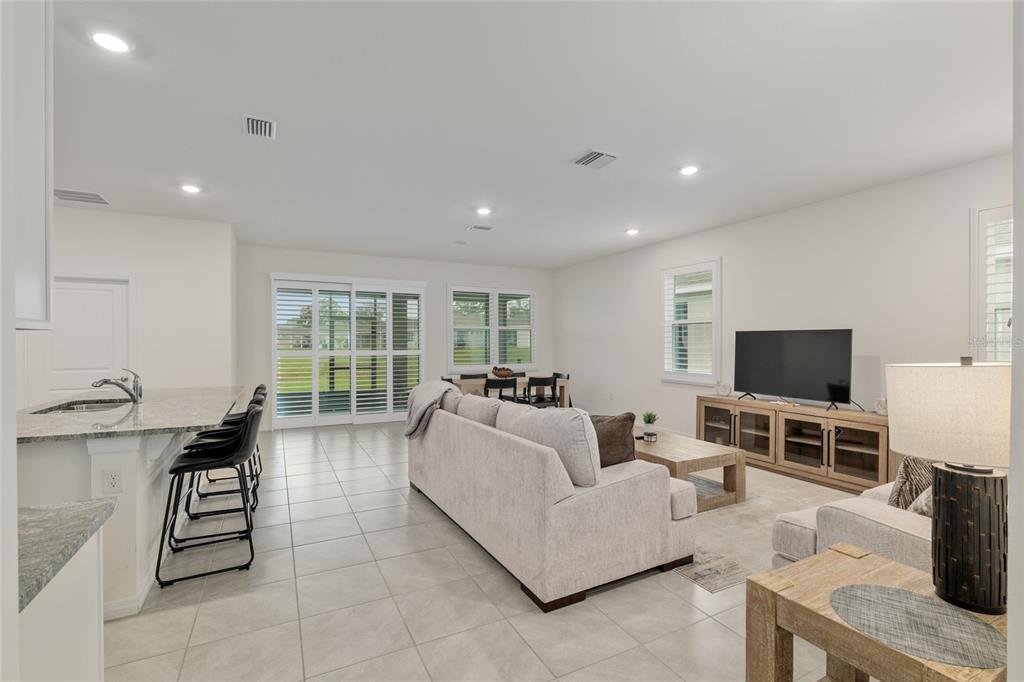 5246 Northwest 43rd Ln Road Ocala, FL 34482 - Photo 9 of 84 a living room with furniture a flat screen tv and a large window