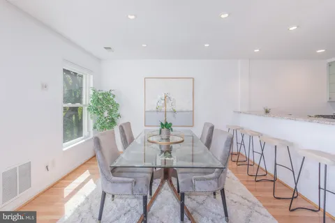 a kitchen with granite countertop kitchen island stainless steel appliances a table and chairs in it
