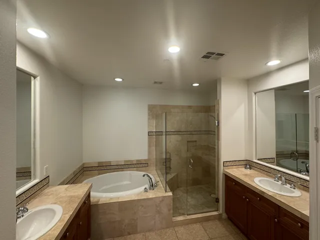 a bathroom with a double vanity sink toilet and shower