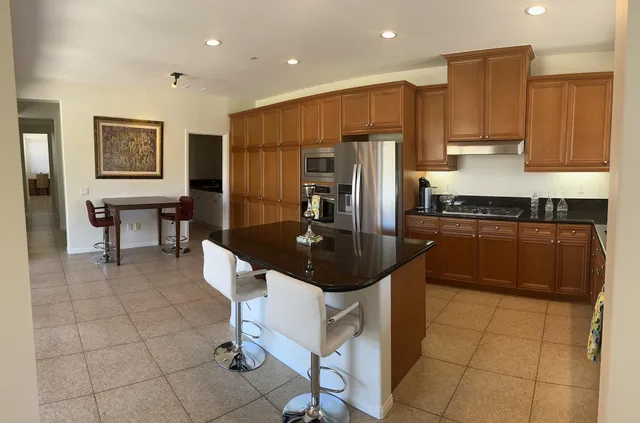 a kitchen with stainless steel appliances a sink a stove a microwave a counter top space and cabinets