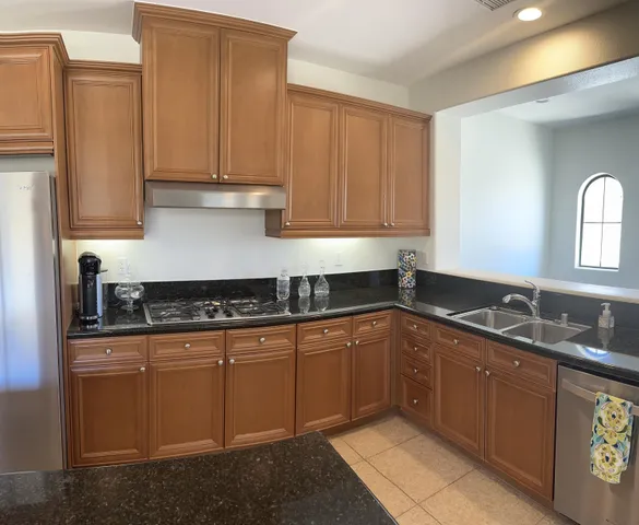 a kitchen with stainless steel appliances granite countertop a sink stove and cabinets