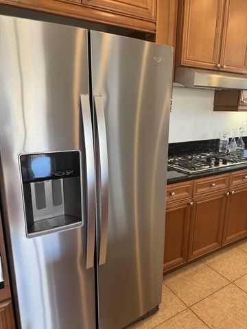 a metallic refrigerator freezer sitting in a kitchen