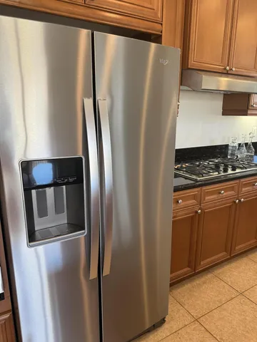 a metallic refrigerator freezer sitting in a kitchen