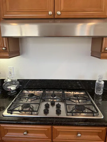 a stove top oven sitting inside of a kitchen