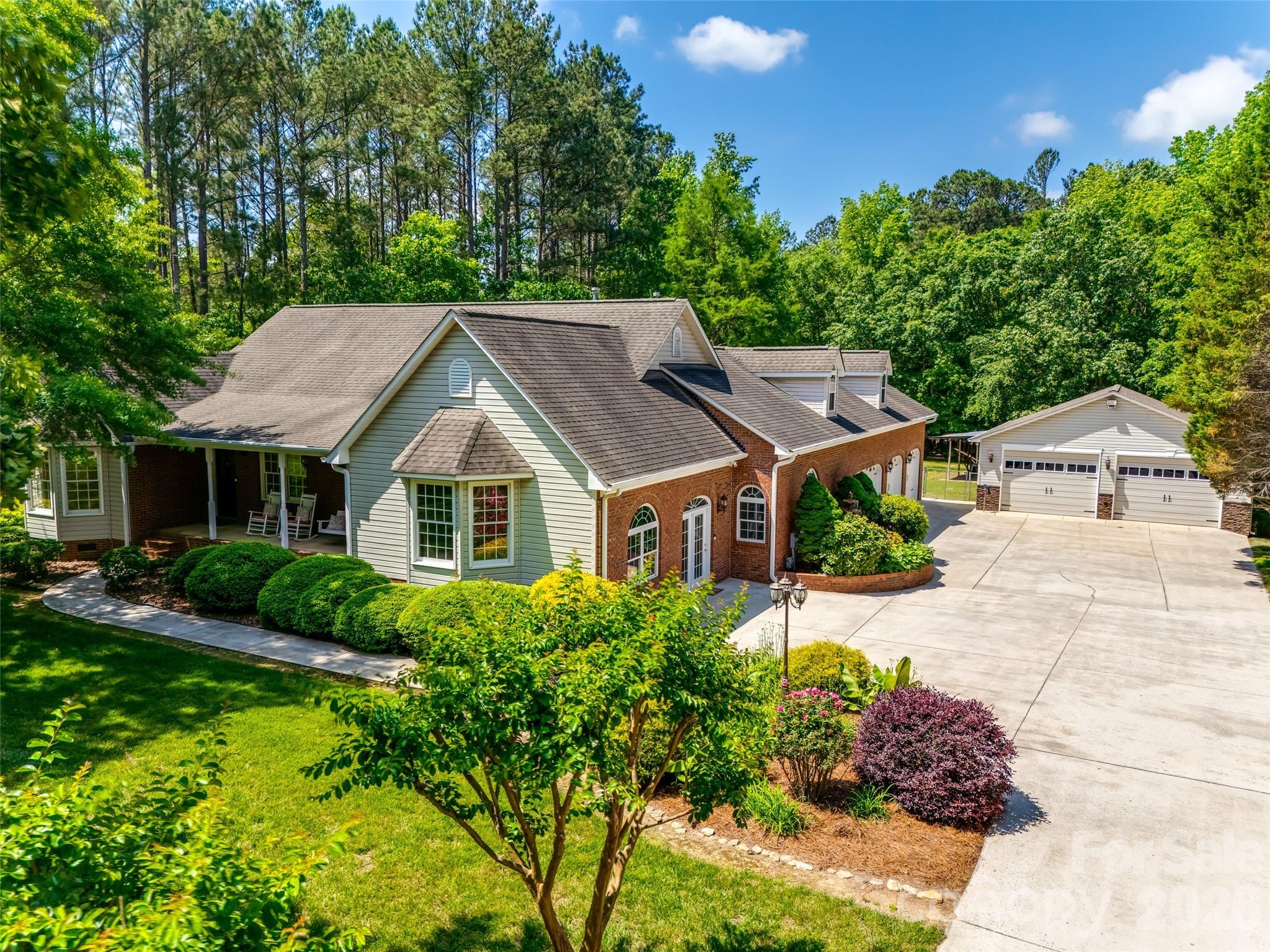 a view of house with garden and tall trees