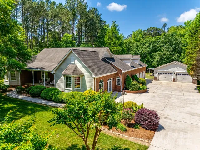 a view of house with garden and tall trees