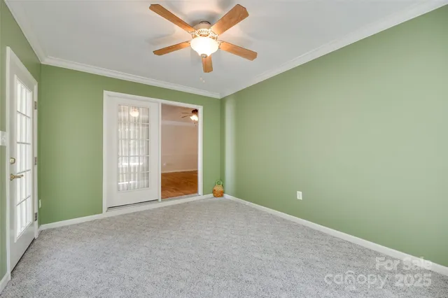 a view of livingroom with window ceiling fan and front door