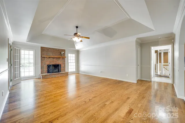 an empty room with wooden floor and fireplace