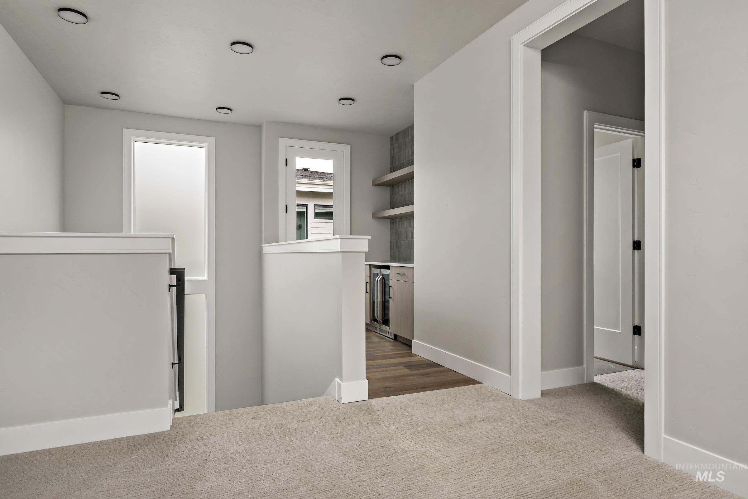 11709 North Rabbitbrush Way Boise, ID 83714 - Photo 20 of 31 Corridor with an upstairs landing, dark carpet, and wine cooler