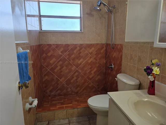 an empty room with ceiling fan and window